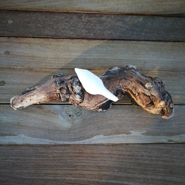 A single ceramic bird on driftwood
