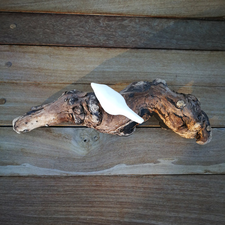 A single ceramic bird on driftwood